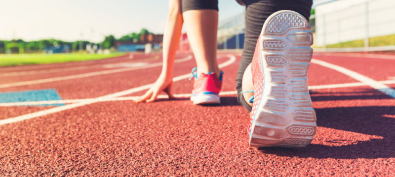 Female athlete on the starting line of a stadium track